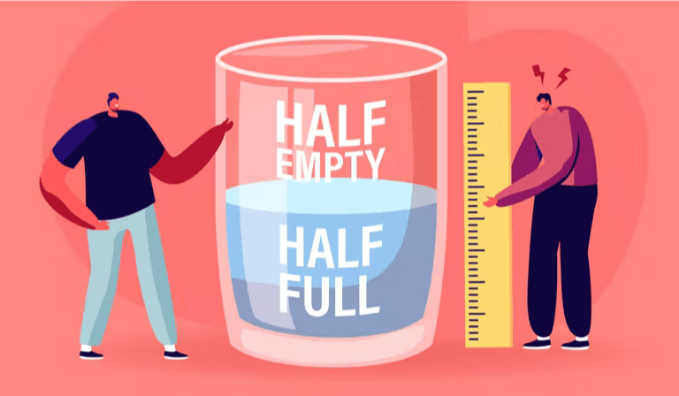 two cartoon figures measuring a large glass containing water. The glass reads 'Half Empty' on the top half and 'Half Full' on the bottom half.